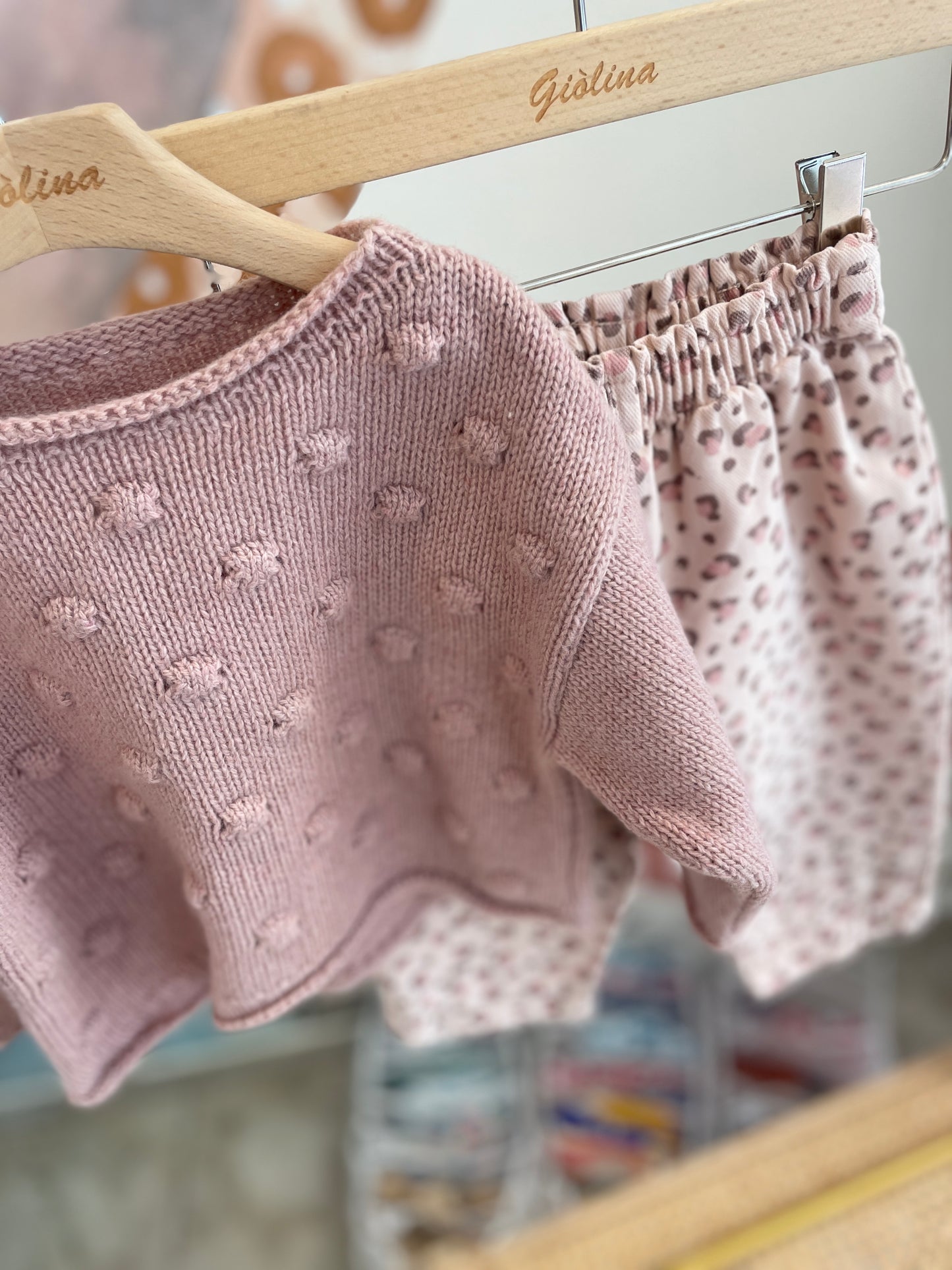 Pullover rosa con pompom pantalone maculato e t-shirt con colletto