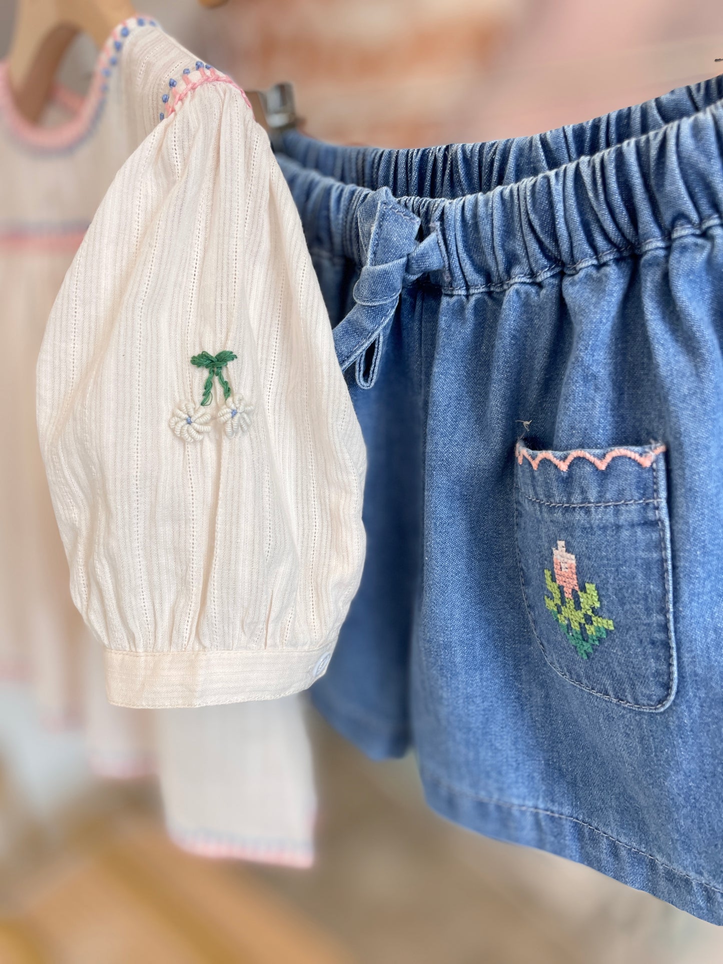 Blusa crema con passamaneria rosa, manica a palloncino ricamata e shorts denim taschine ricamate