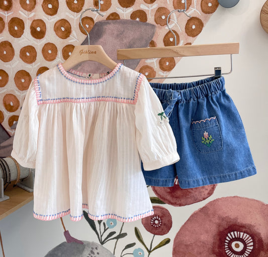 Blusa crema con passamaneria rosa, manica a palloncino ricamata e shorts denim taschine ricamate