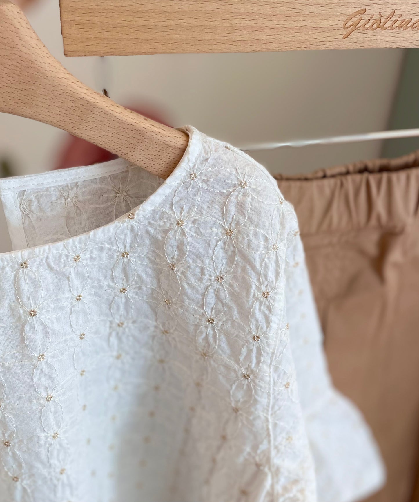 Blusa ricamata con gonna a pieghe