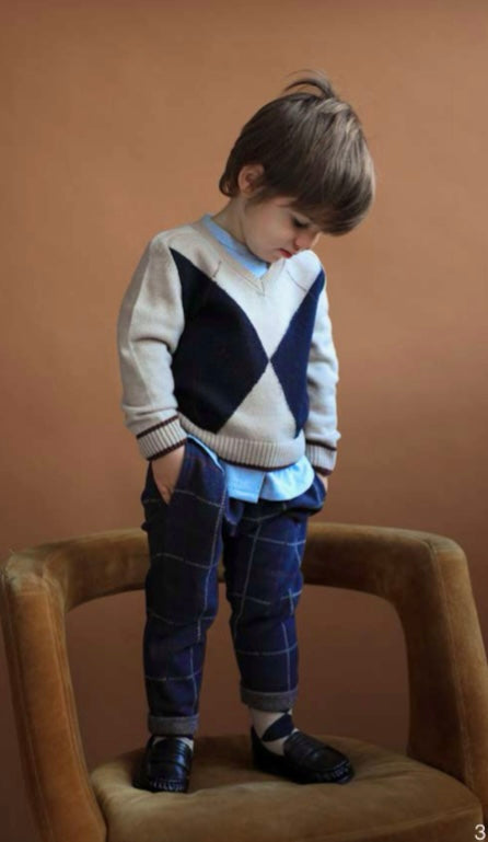Pullover losanghe con scollo a V , camicia azzurra con colletto e pantalone beige o  scozzese